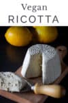 vegan ricotta on a serving wooden cheese table, shaped sliced with a cheese cutter