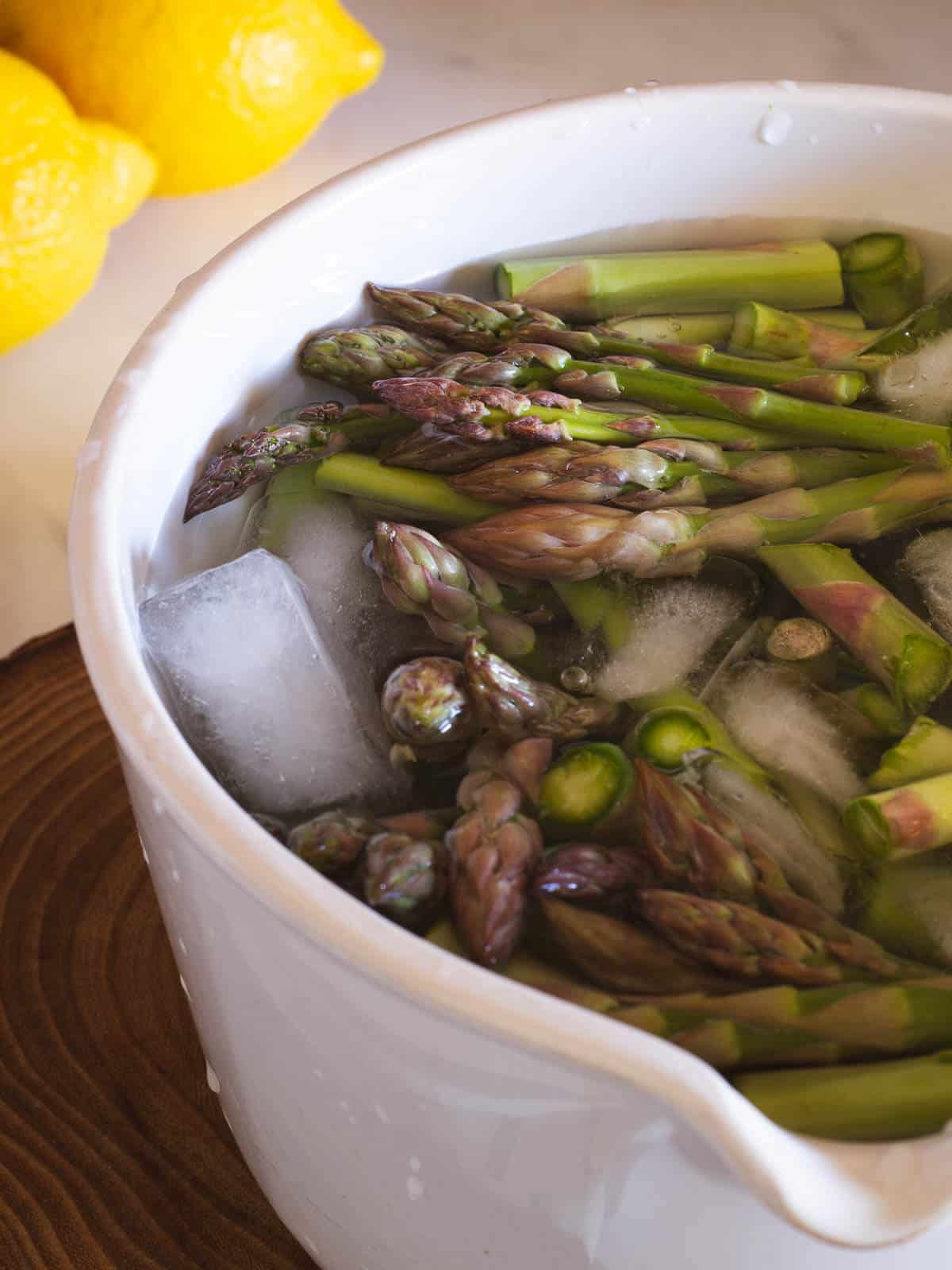 cut asparagus in a sacuepan with water and ice cubes to keep them green