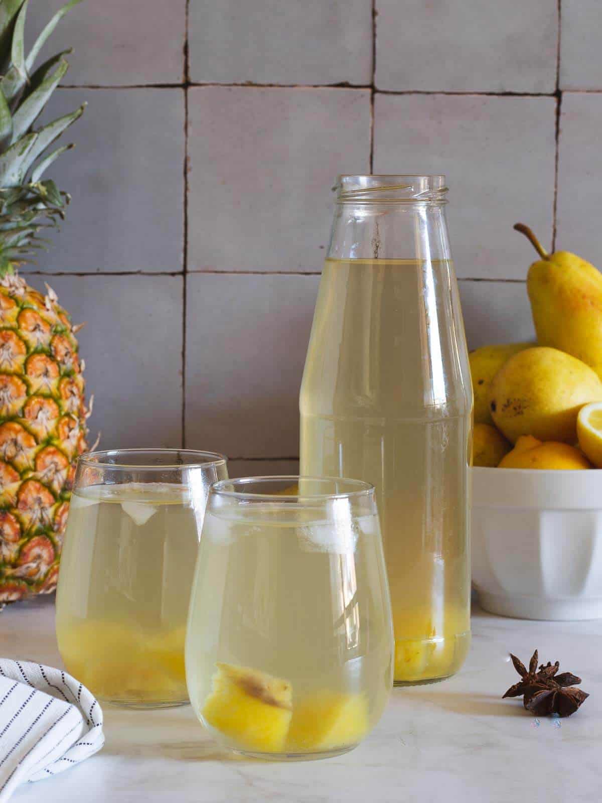 pineapple water bottled with two served glasses