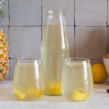 two glasses and one bottle of served pineapple water.
