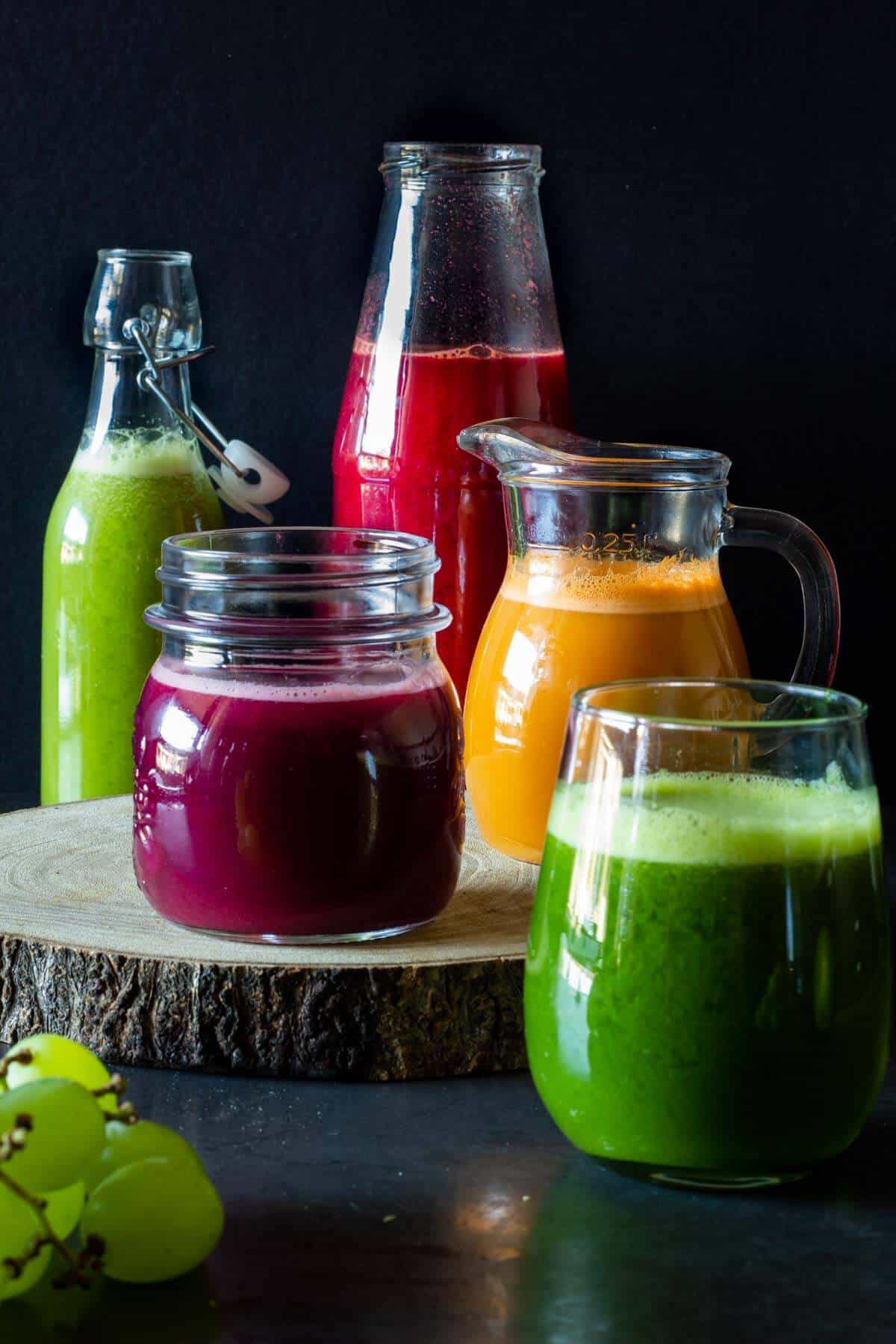 five types of colorful juices in glass containers.