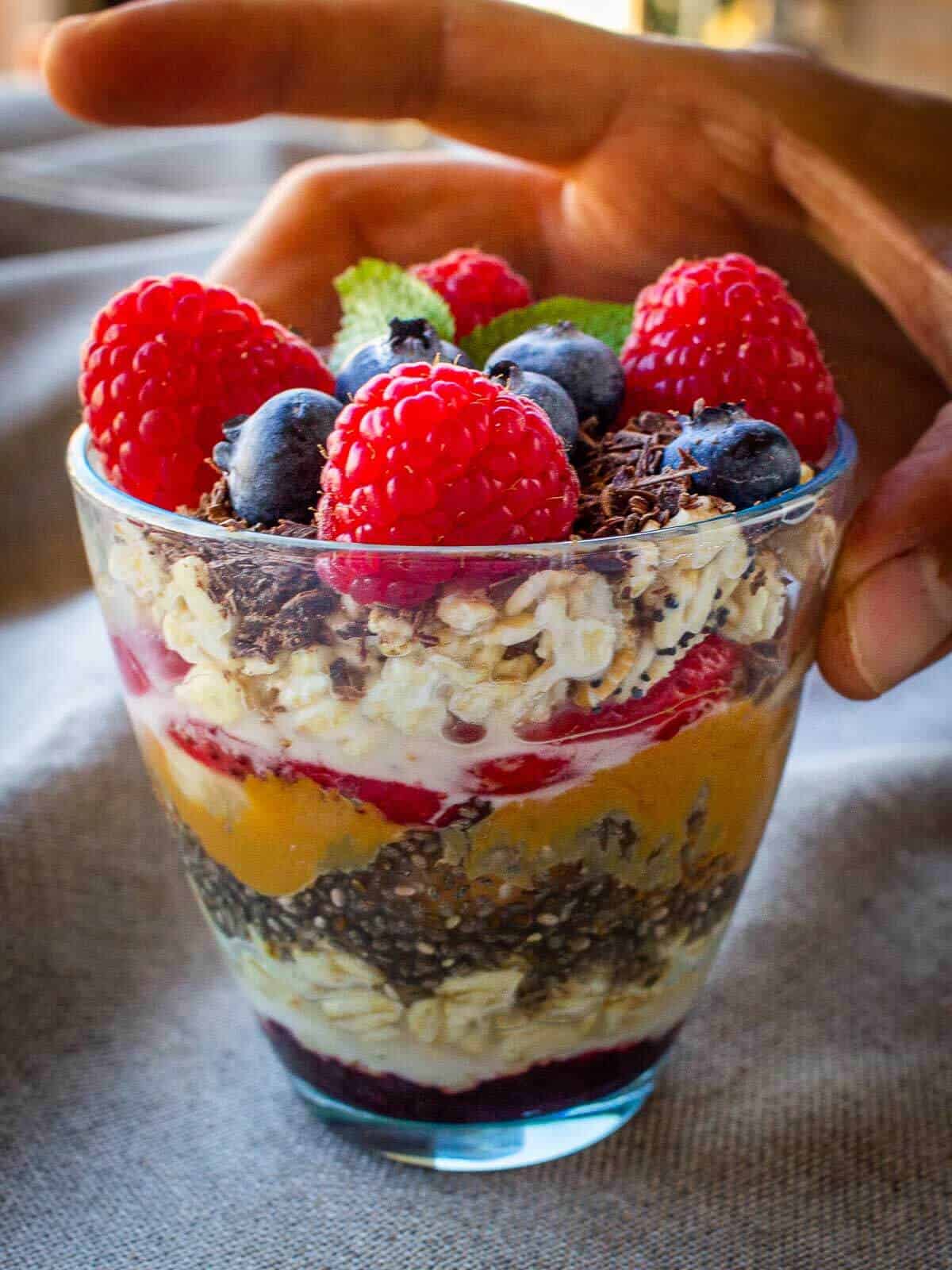 topping Oats and Chia Pudding with fresh blueberries, raspberries, and cocoa nibs.