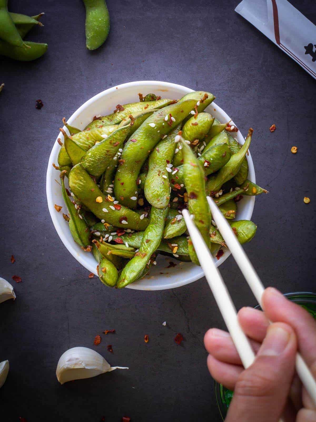 garlic edamame served with chopsticks