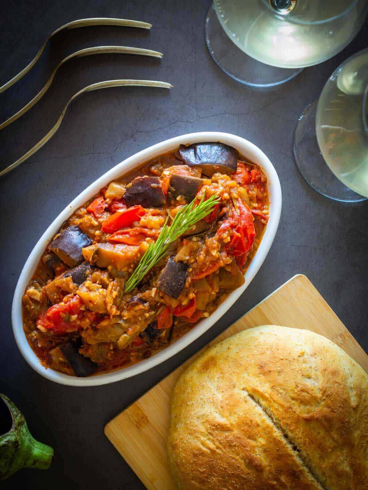 plated eggplant stew with a bread loaf.