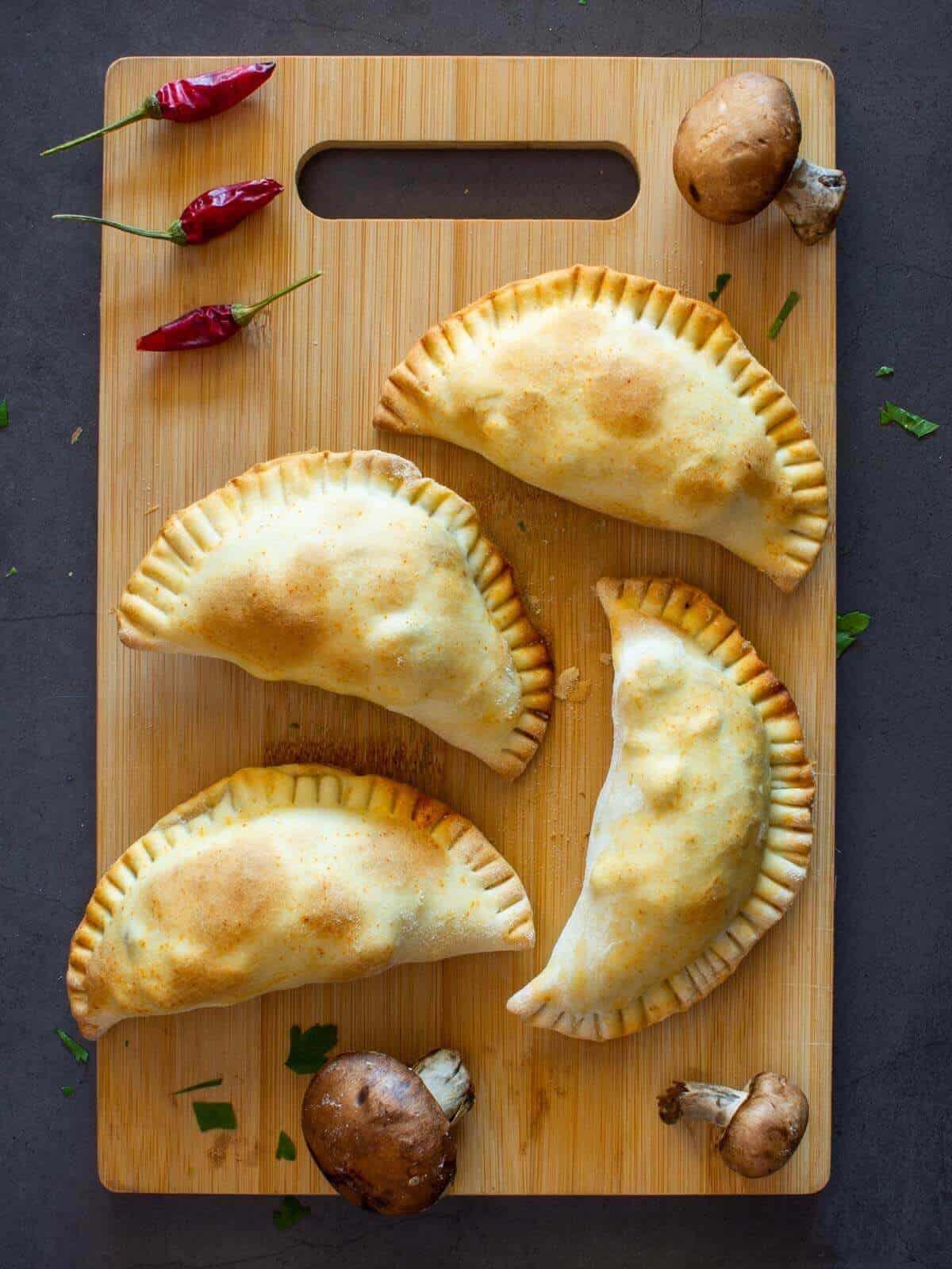 baked Mushrooms Empanadas served over a wooden table.