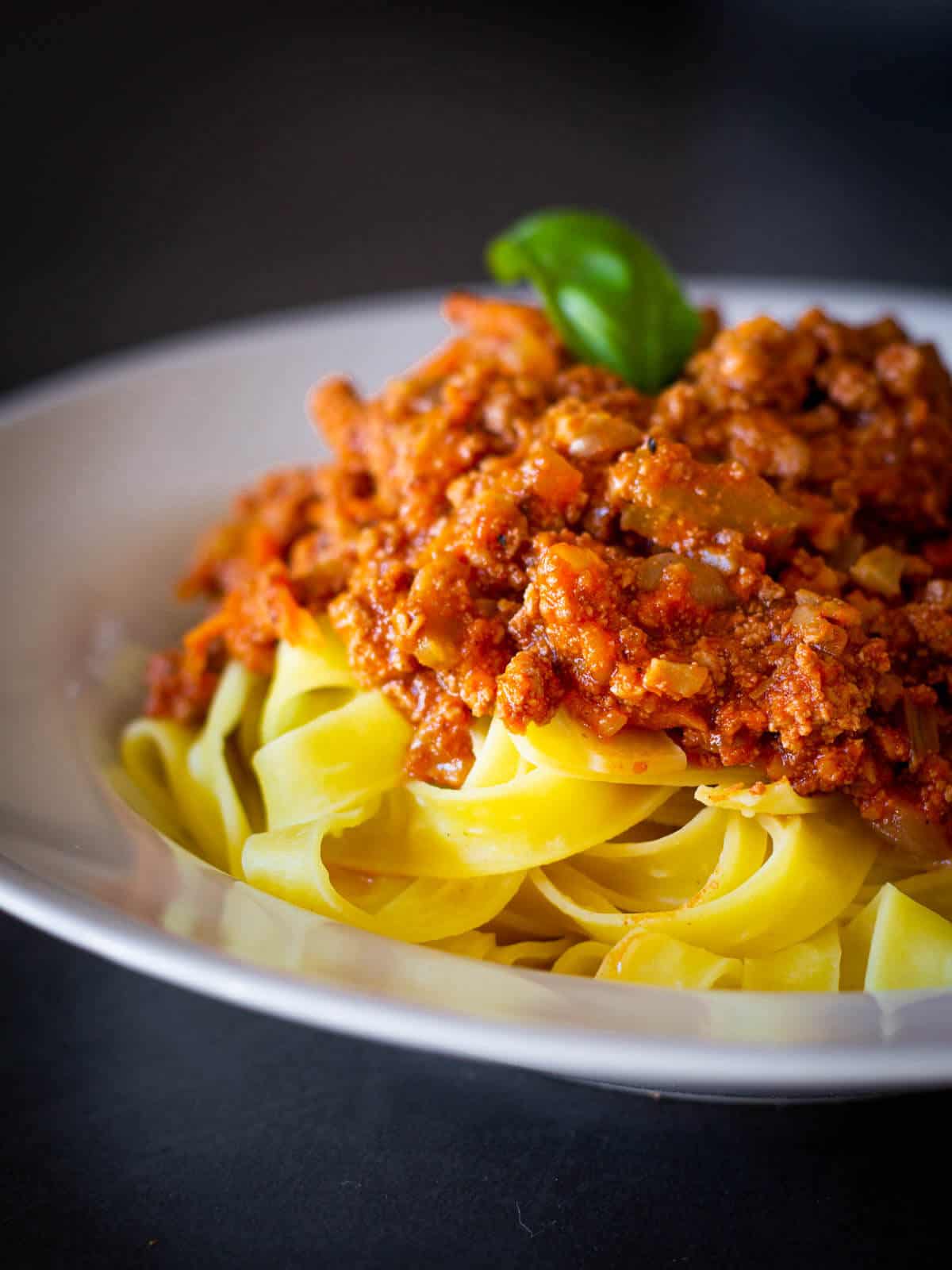 Vegan Bolognese sauce plated with fettuccini pasta.