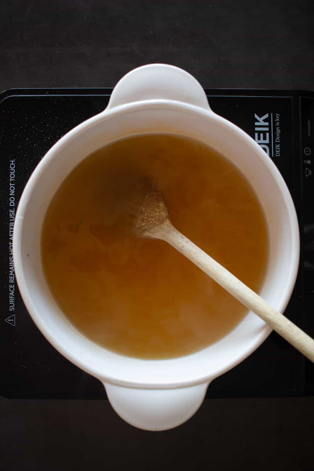 vegetable stock with wooden spoon.