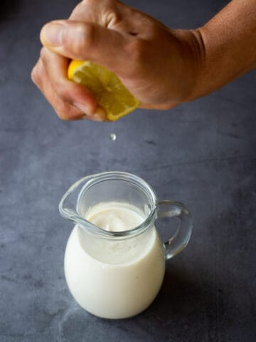 squeezing lemon on plant milk for homemade buttermilk