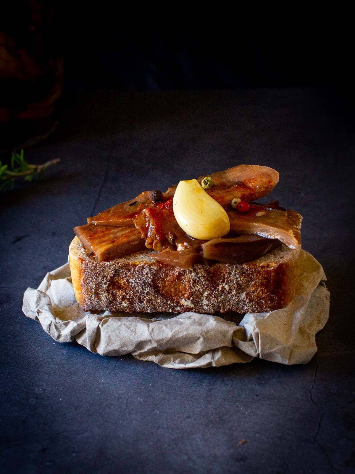 Pickled Eggplants on a crostini tapa with pickled garlic on top.