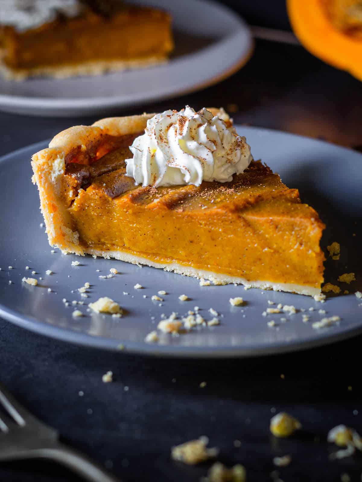 vegan pumpkin pie portion with whipped cream.