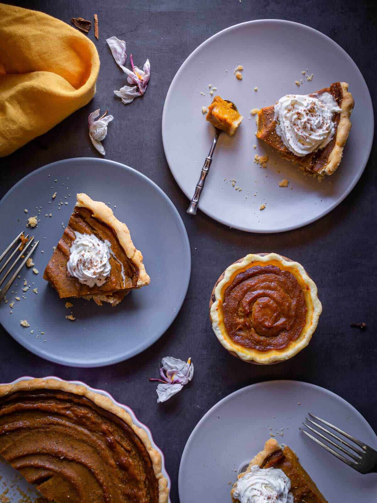 vegan pumpkin pie portions served on small plates over a table.