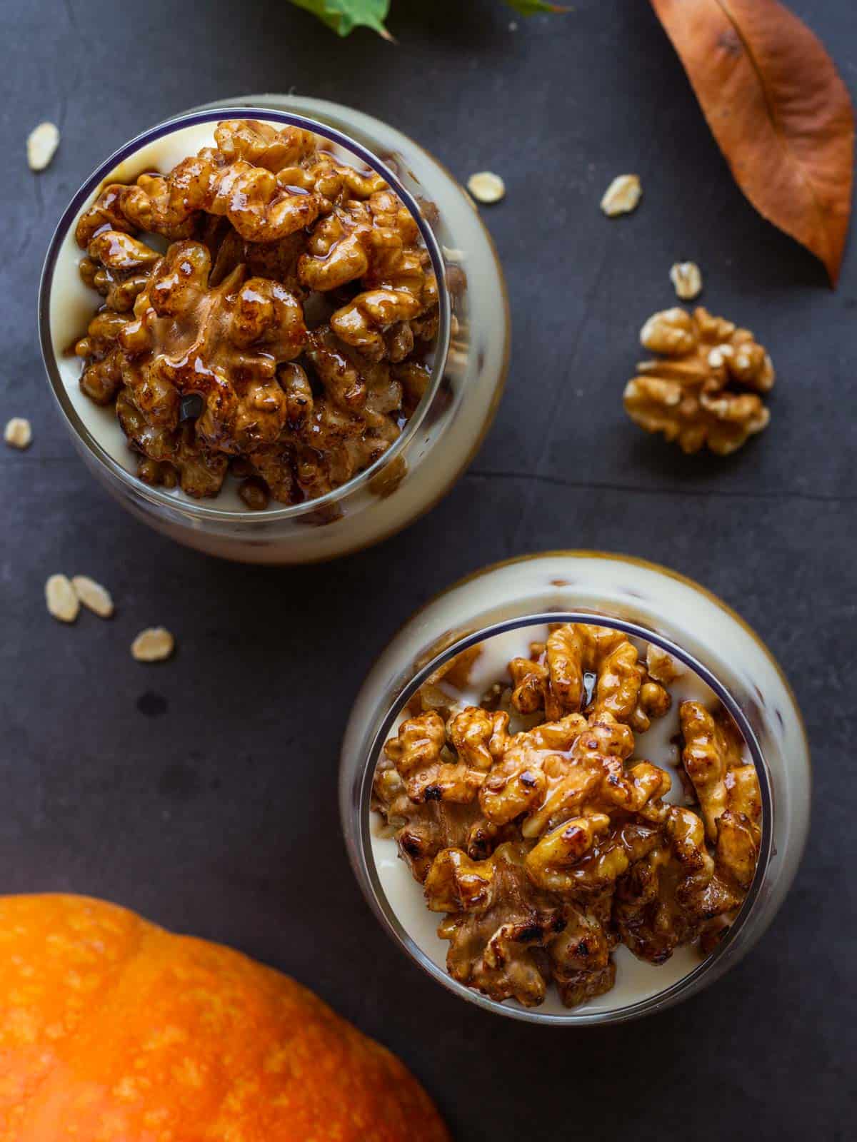 two glasses of ovenight oats topped with caramelized walnuts.