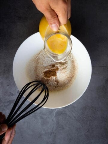 mixing the liquid pumpkin mixture with the sifted dry ingredients with a whisk.