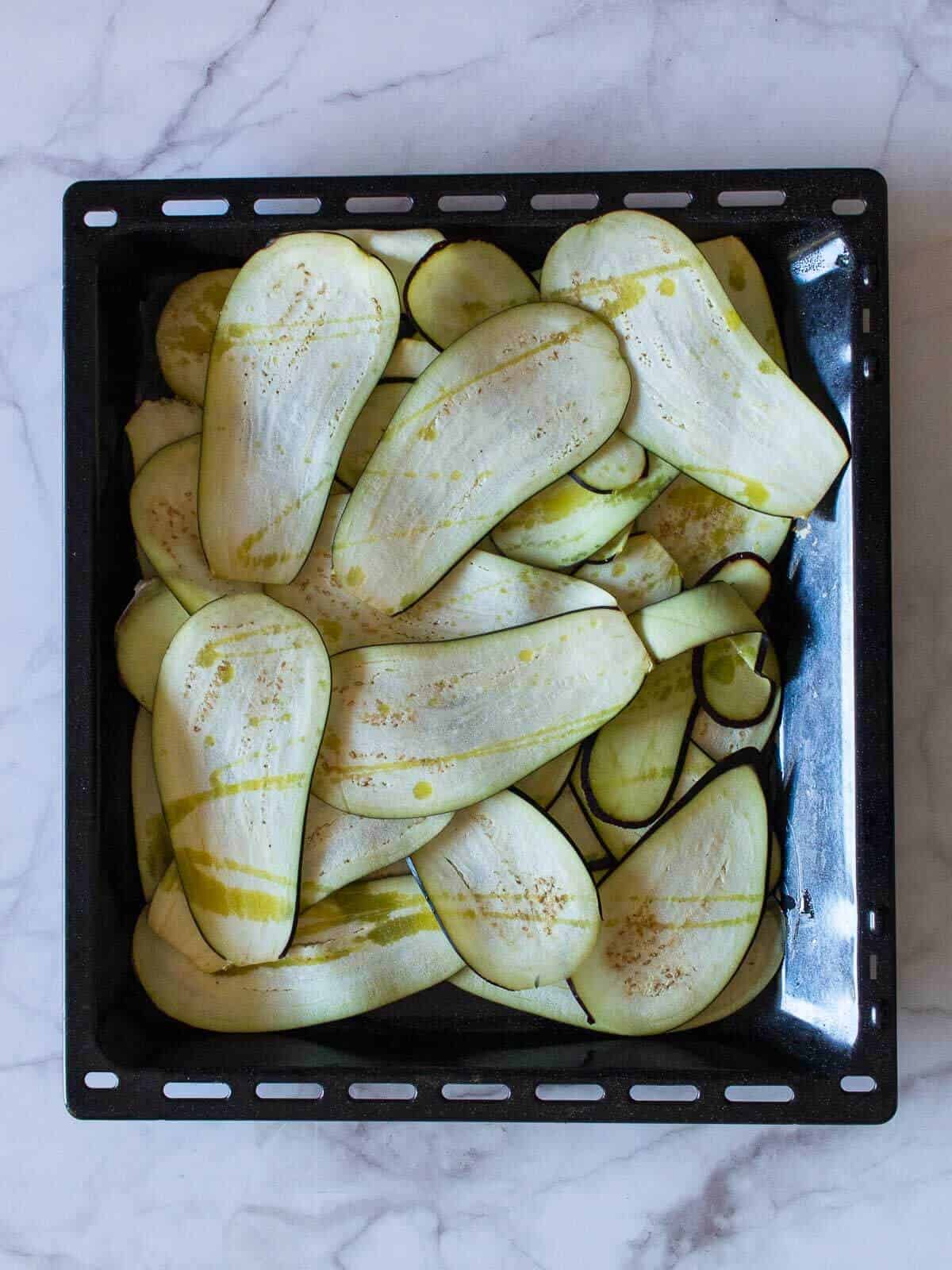 eggplant slices with drizzled olive oil in a oven tray.