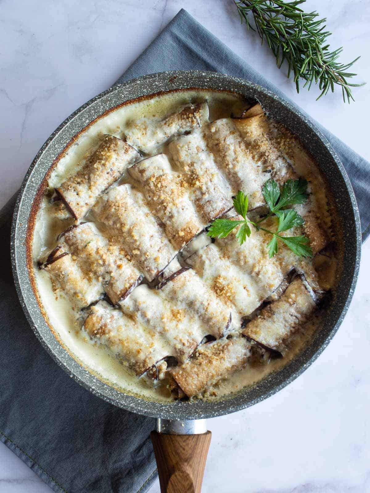 envueltos de berenjena con queso parmesano arriba.