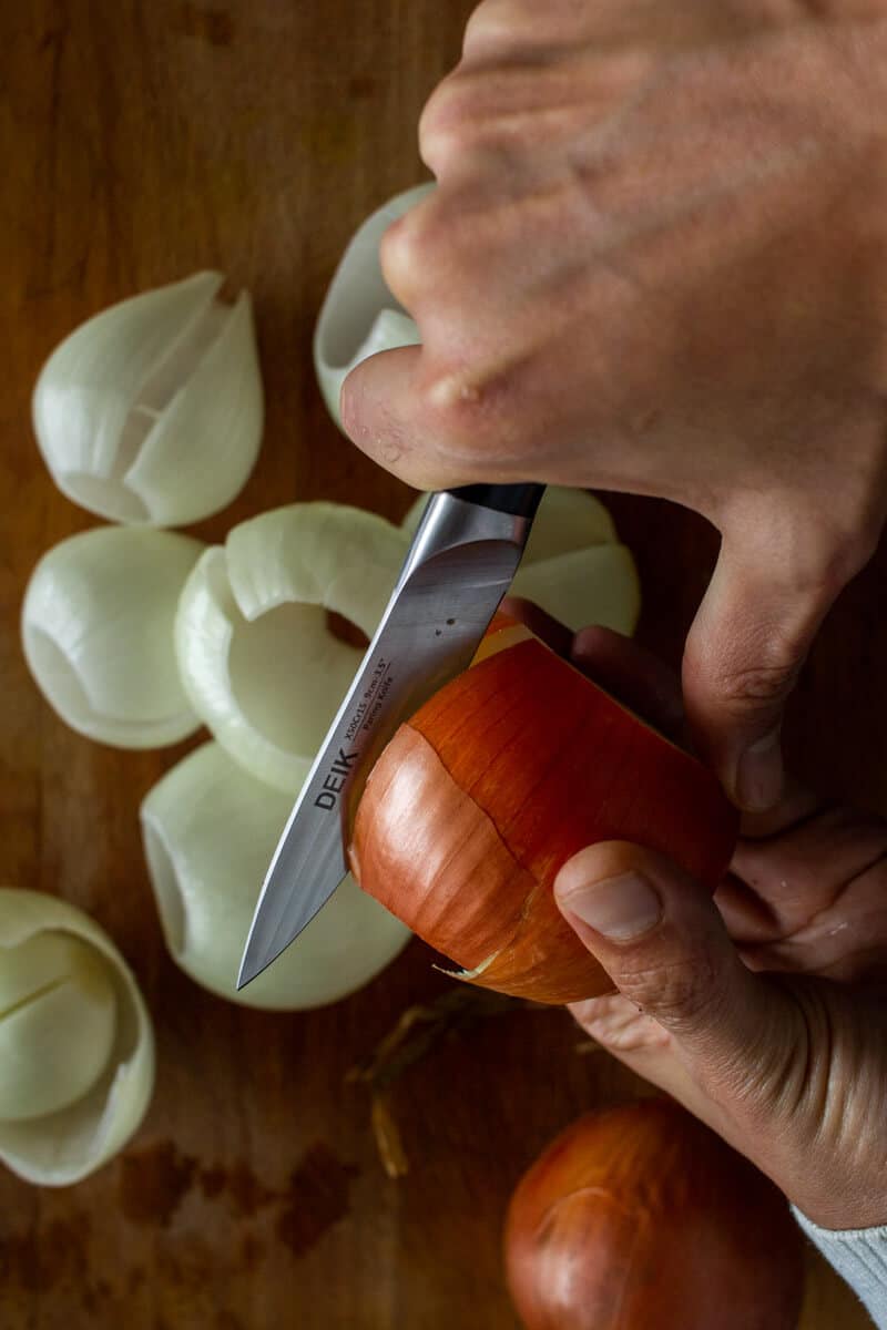 cutting yellow onions from top to bottom.
