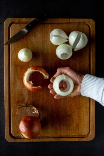 hand showing onions' layers with removed center.