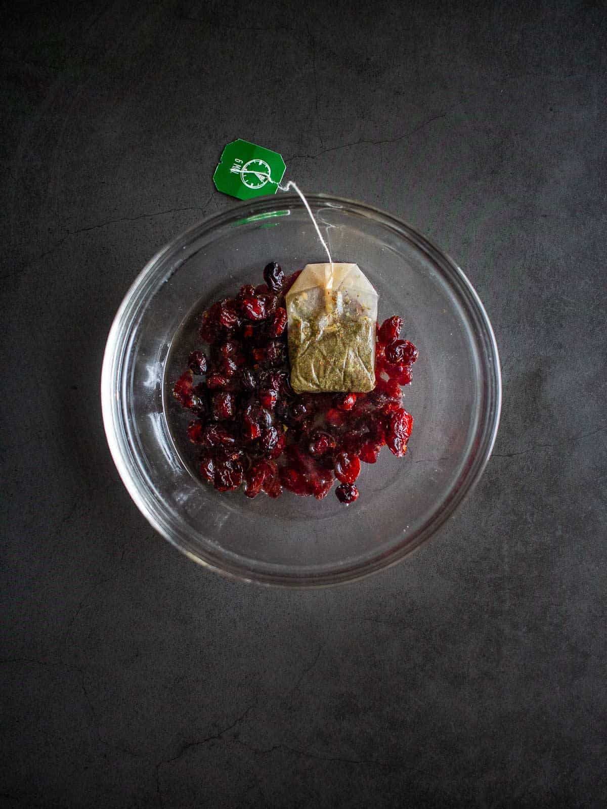 dried cranberries soaking in hot water with a tea bag.