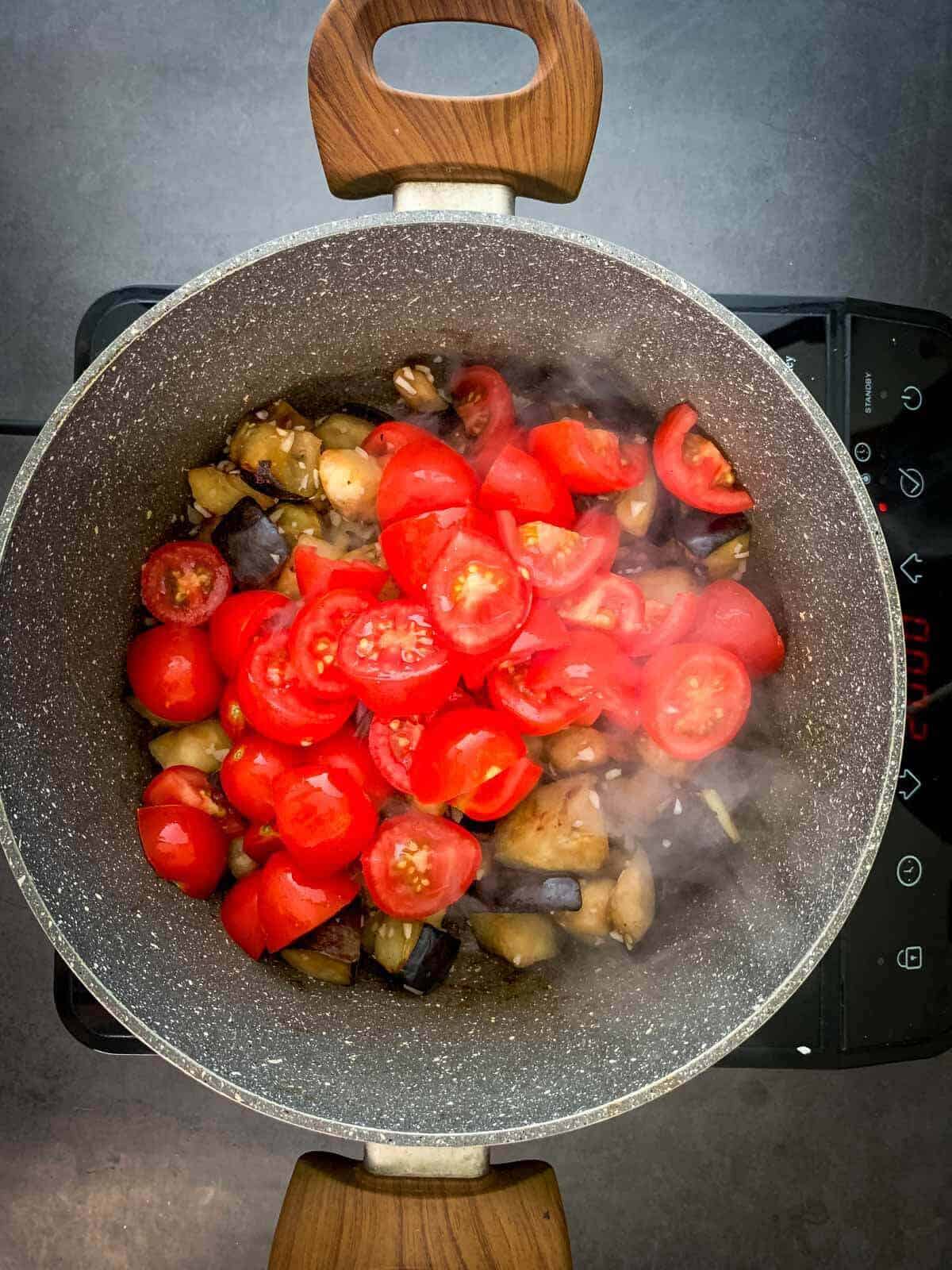add quartered tomatoes into the saucepan.
