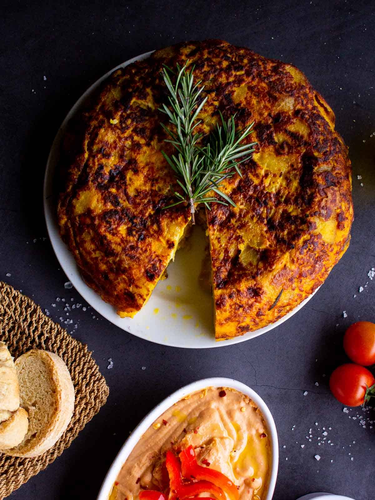 vegan Spanish tortilla served with red pepper hummus and crusty bread.