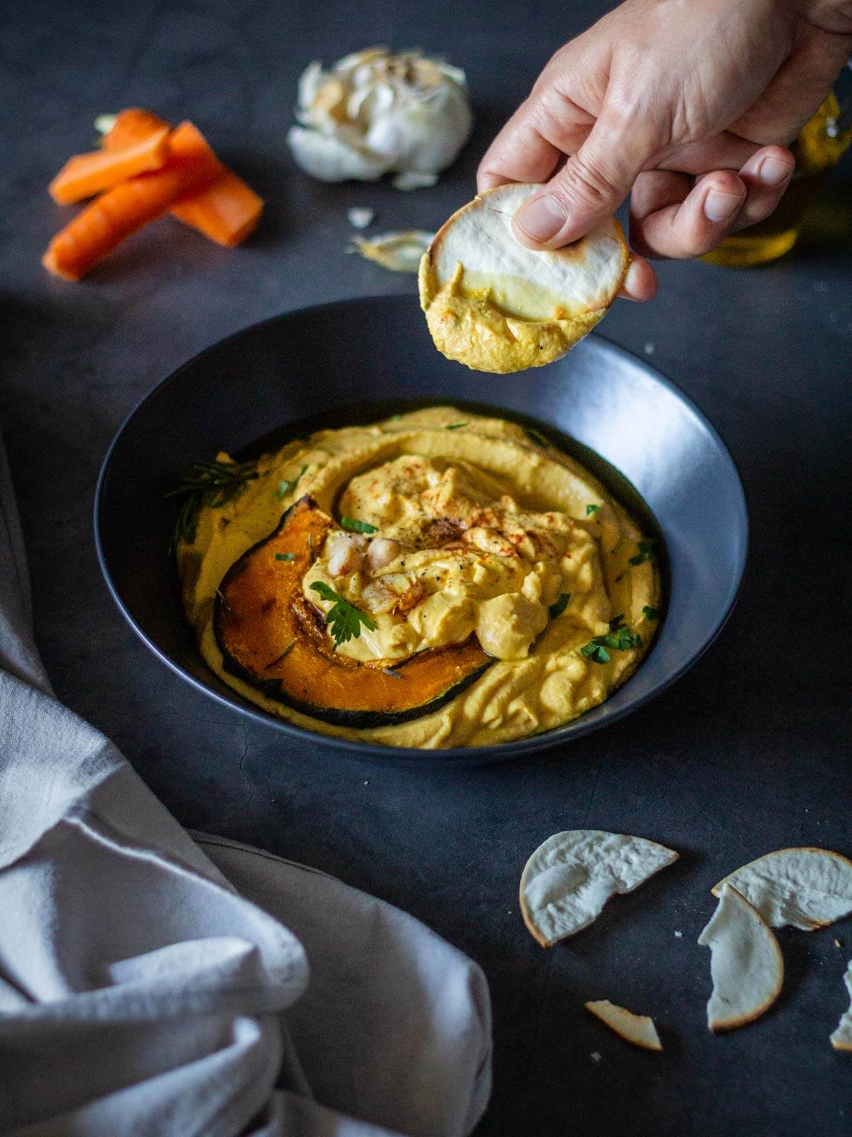 scooping pumpkin hummus with pita chips