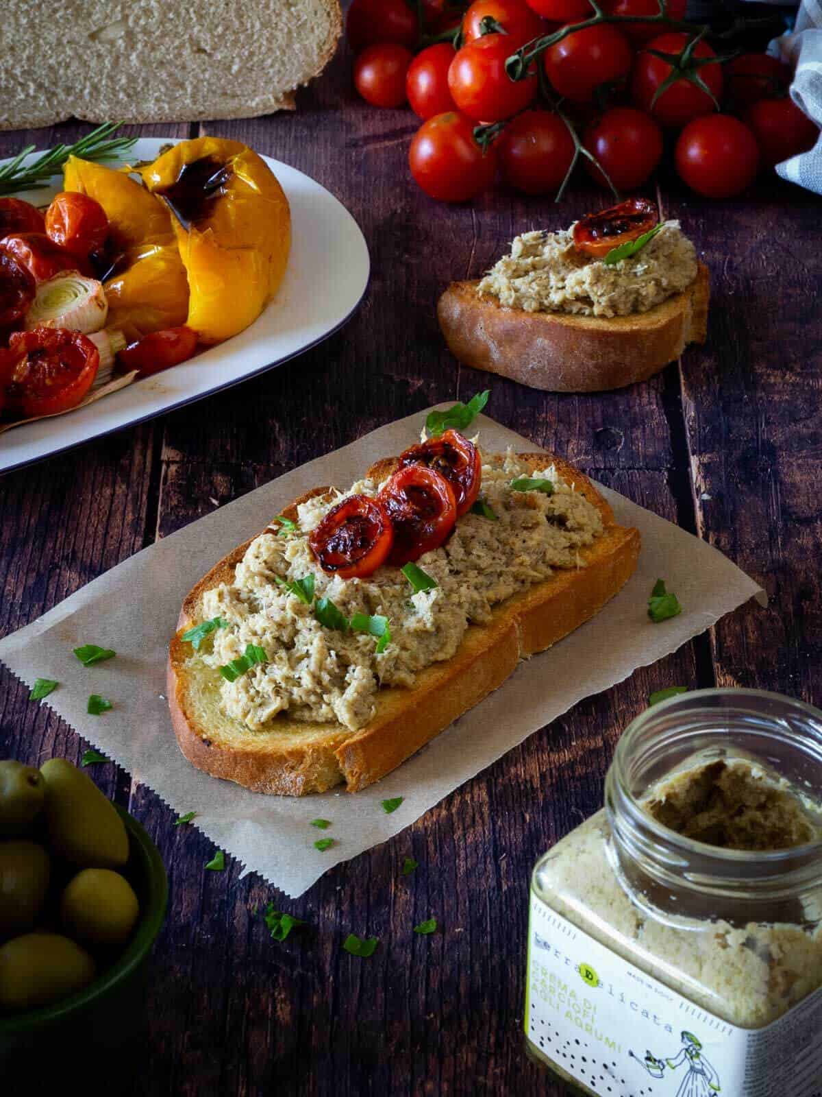 easy bread loaf slice with artichokes spread and charred cherry tomatoes.