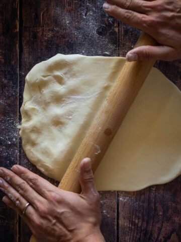 work the vegan empanadas dough with a wooden stick