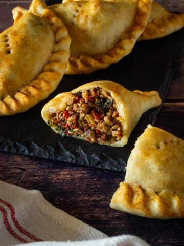 variety of baked empanadas cut in half