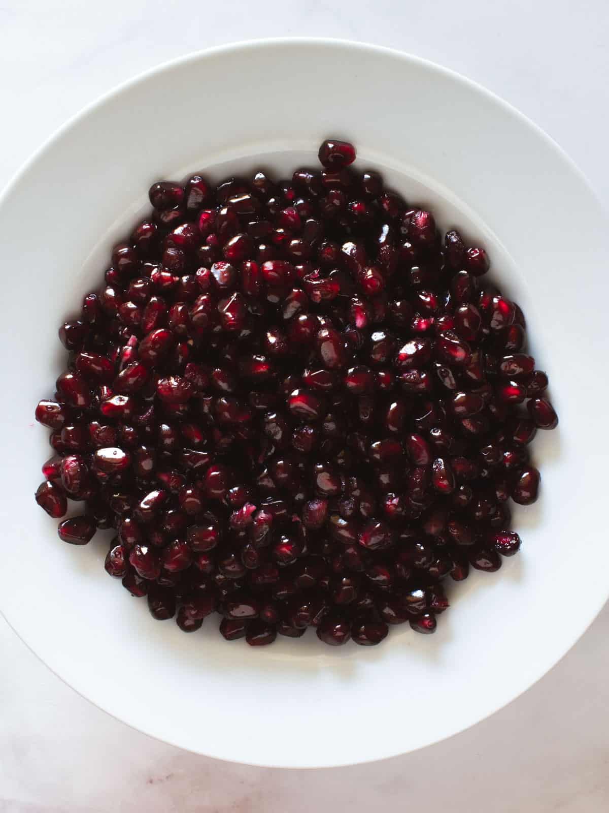 white plate with clean pomegranate seeds