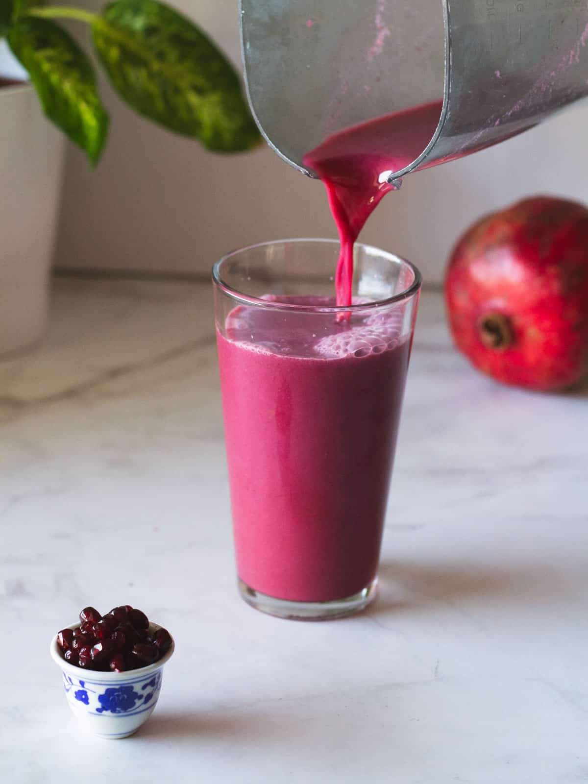 pouring pomegranate juice in glass.