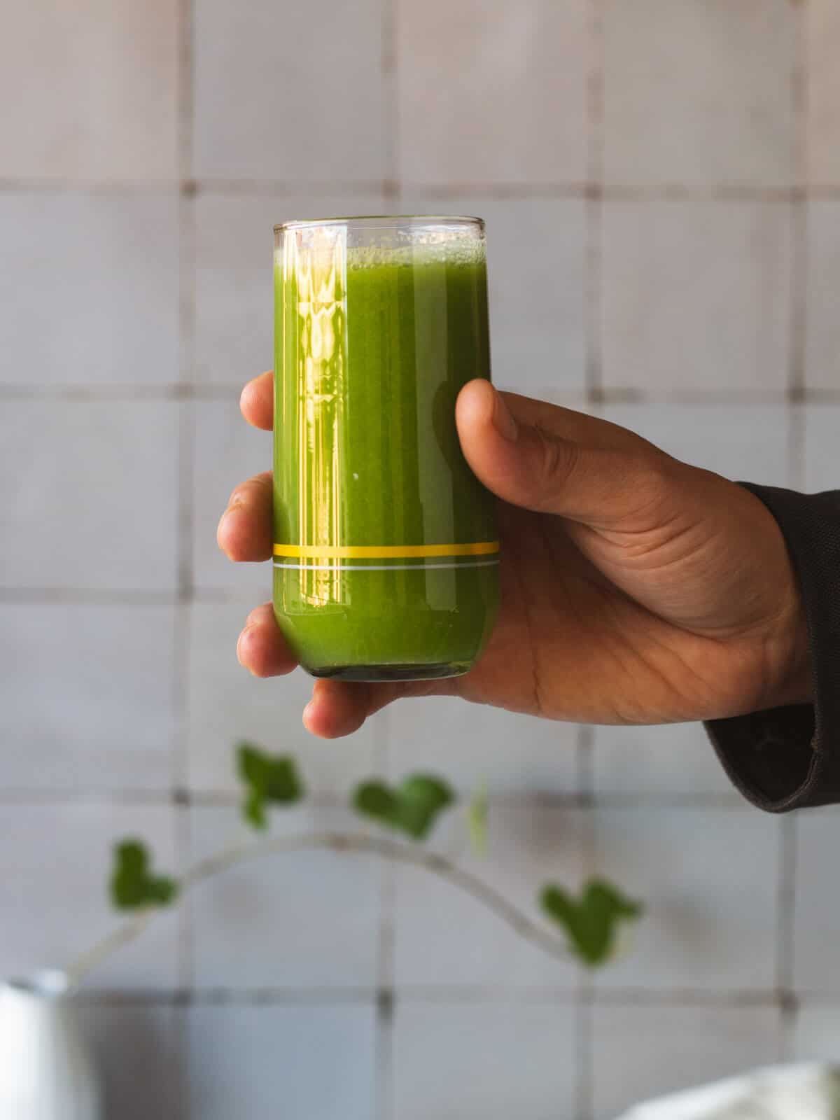 enjoying the benefits of celery juice on empty stomach in a glass.