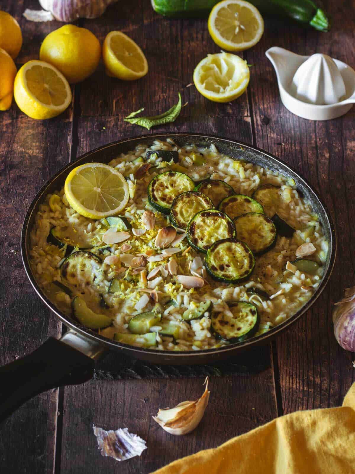 sartén con risotto de verduras sobre mesa de madera.