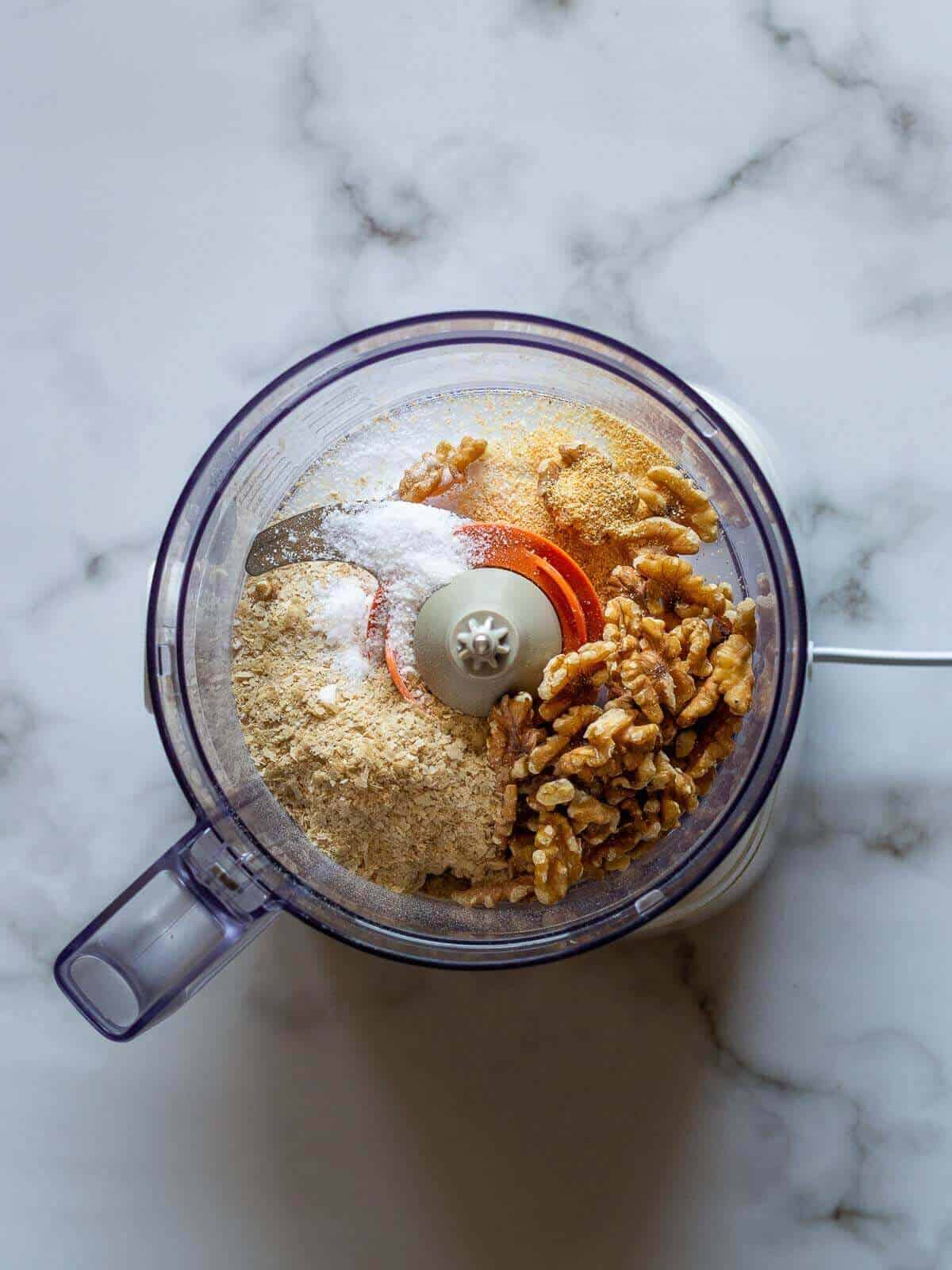 unblended ingredients to make parmesan vegan in a blender's jar.