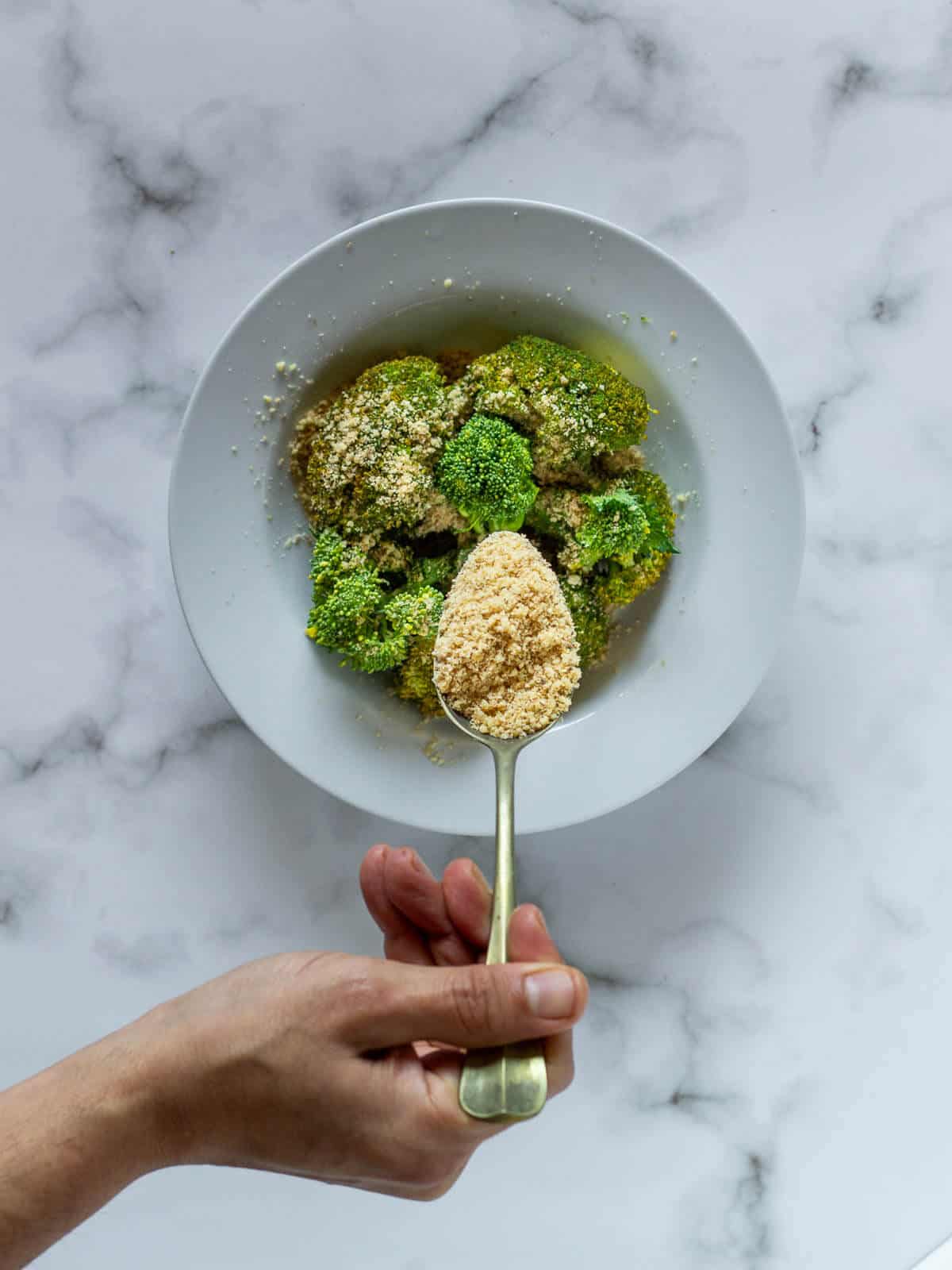 topping steamed broccoli with Vegan Parmesan Cheese.