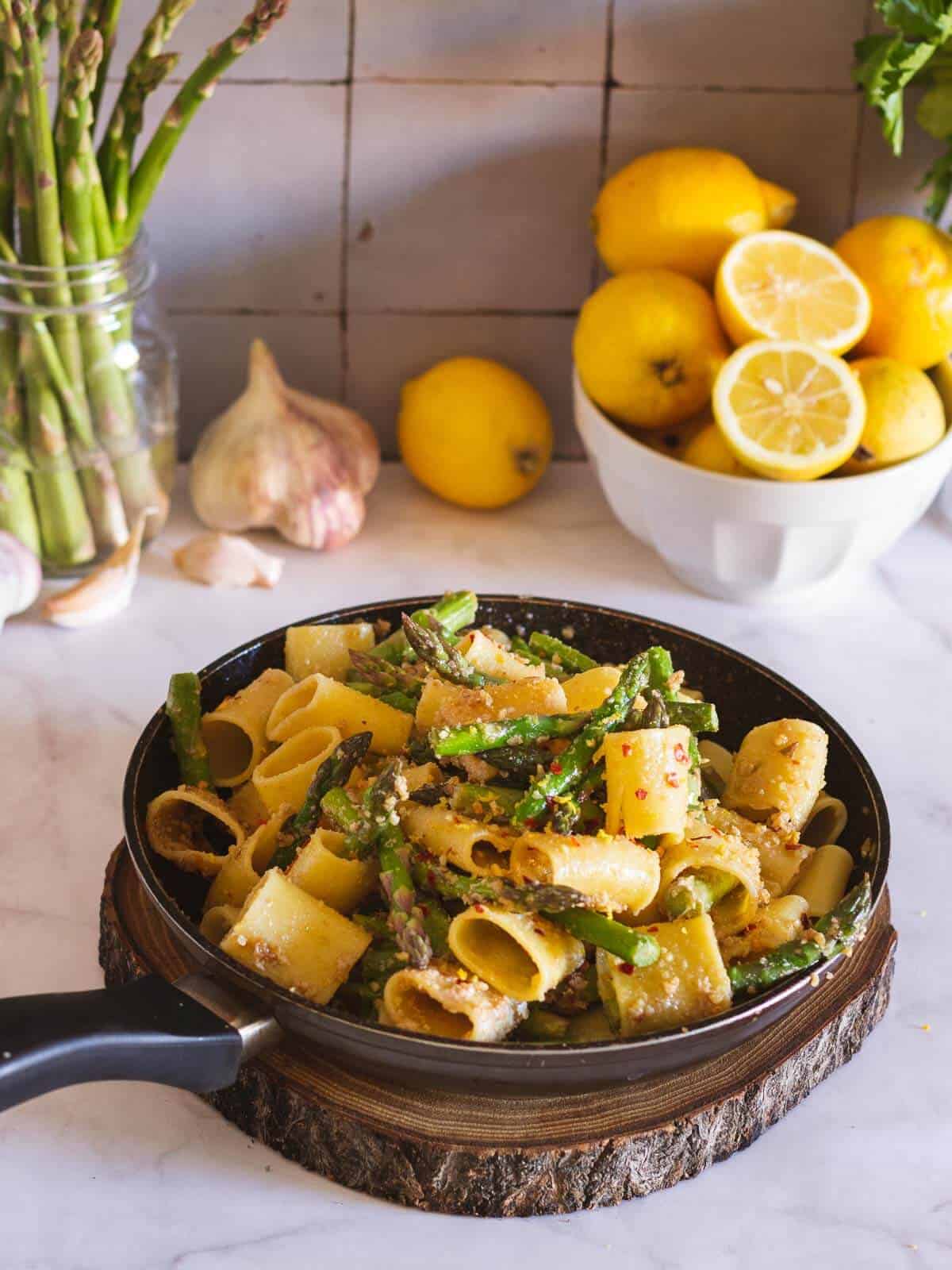 asparagus pasta on a skillet top of wooden board