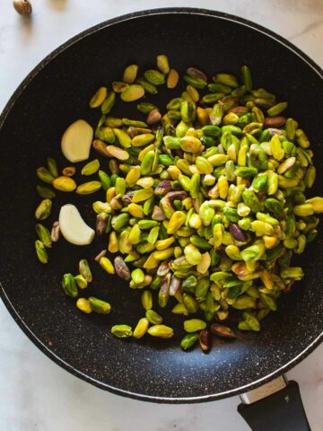 toasting pistachios and garlic in a skillet