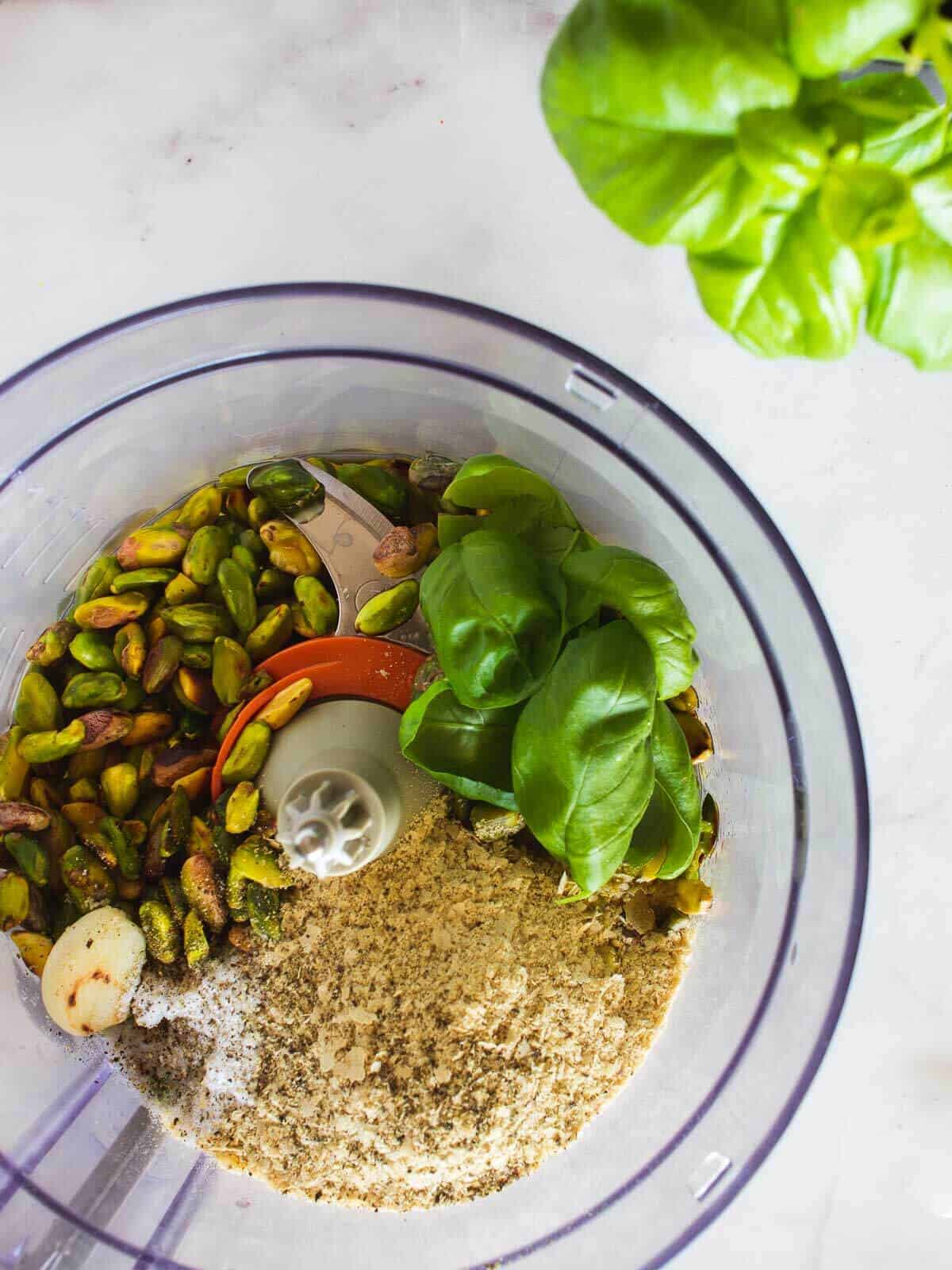 vegan pistachio pesto ingredients in food processot jar