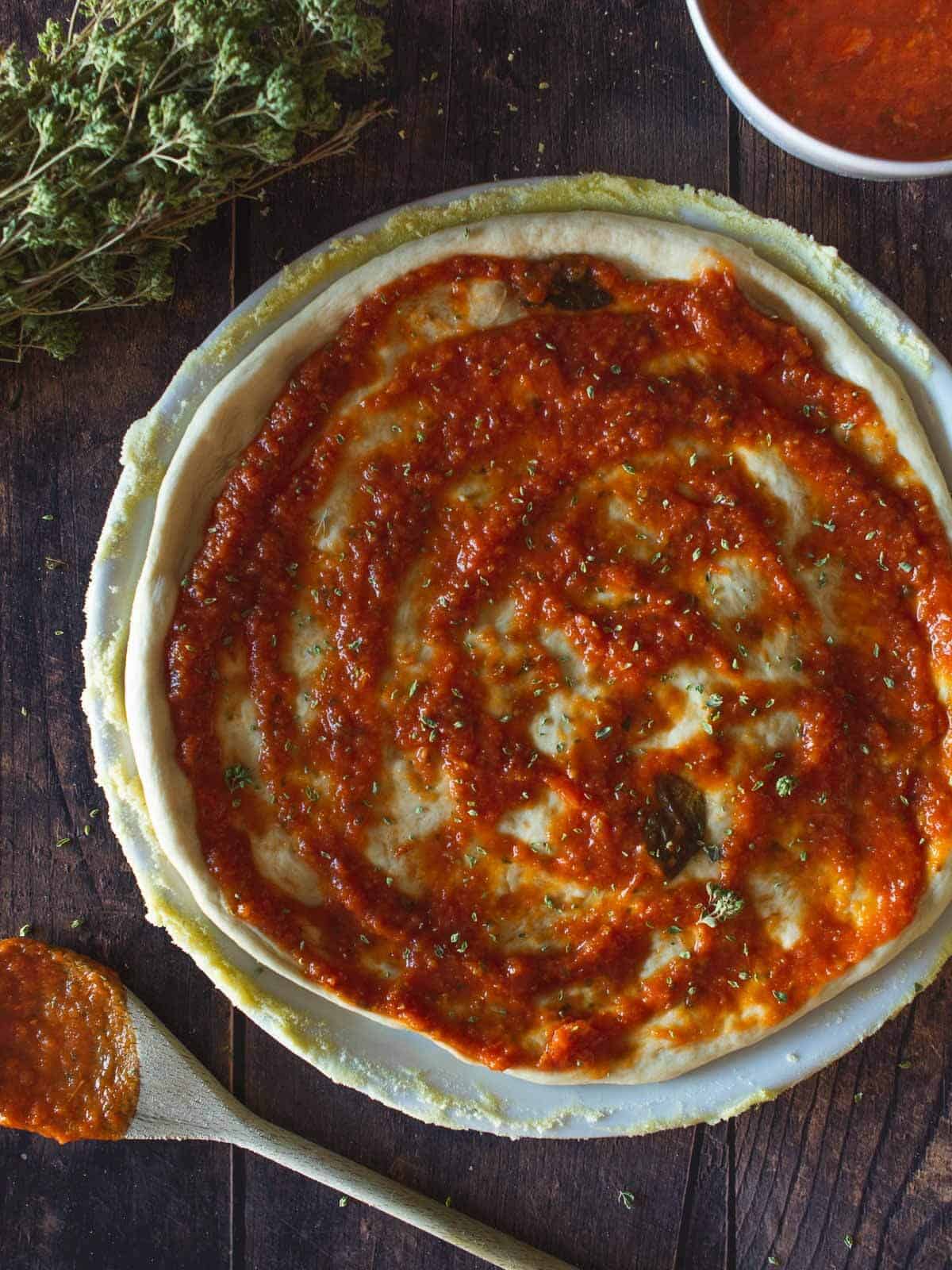 extended pizza dough with tomato sauce