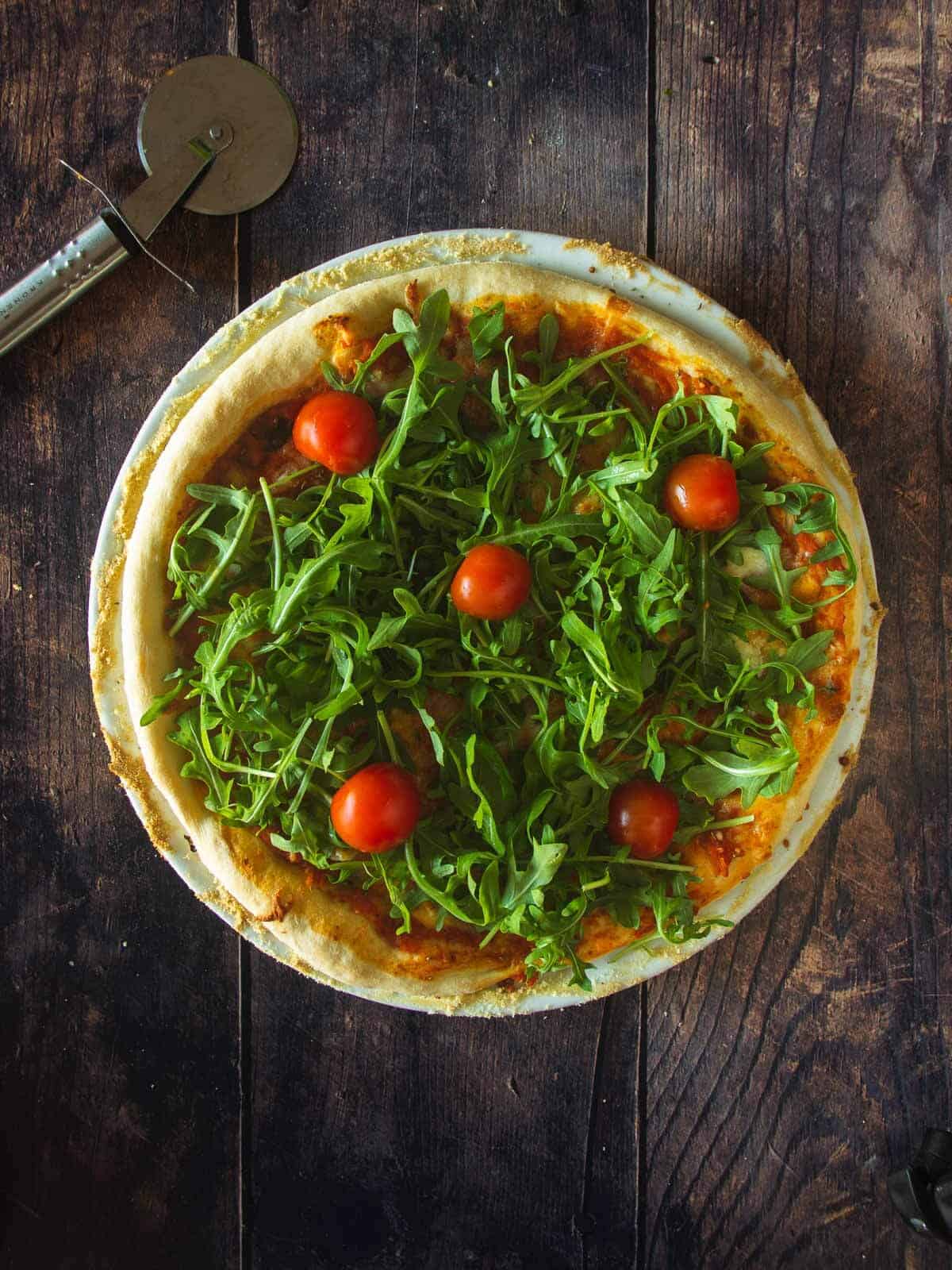 vegan pizza dough with arugula and cherry tomatoes.