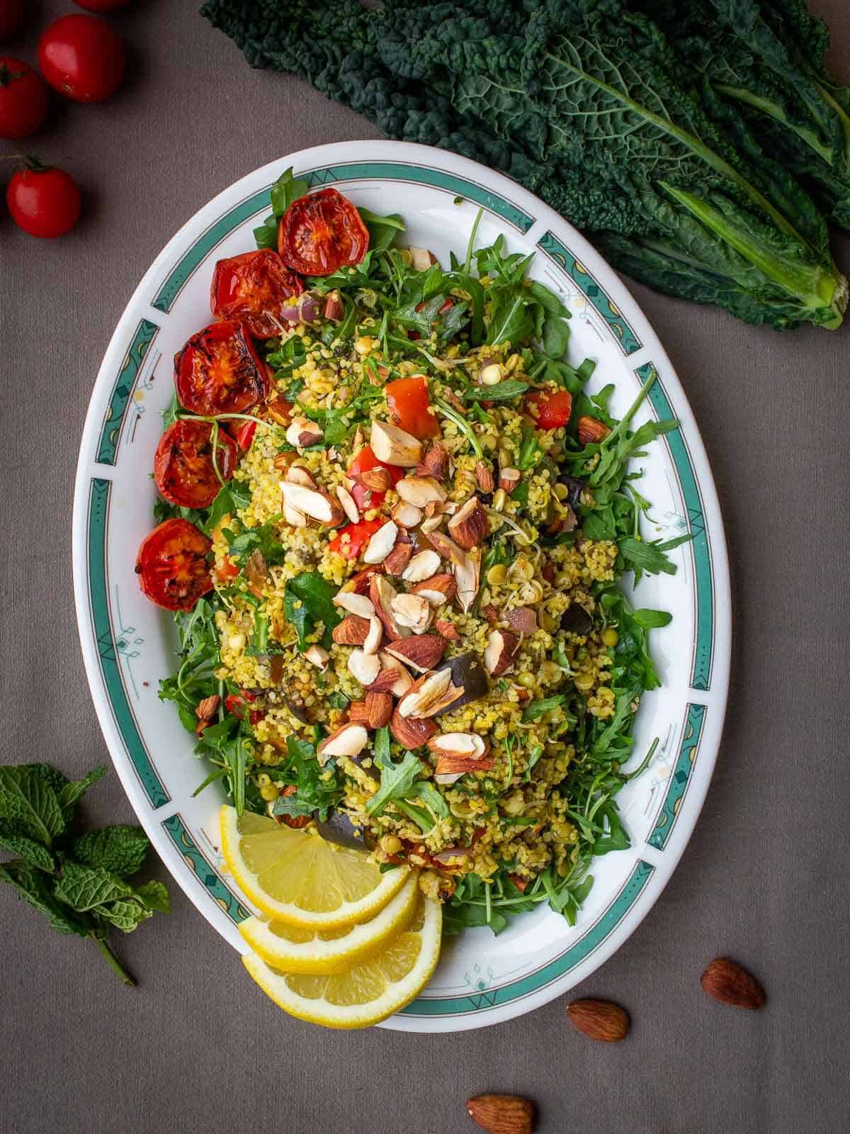 couscous servido en un plato ovalado con tomates cherry rostizados.