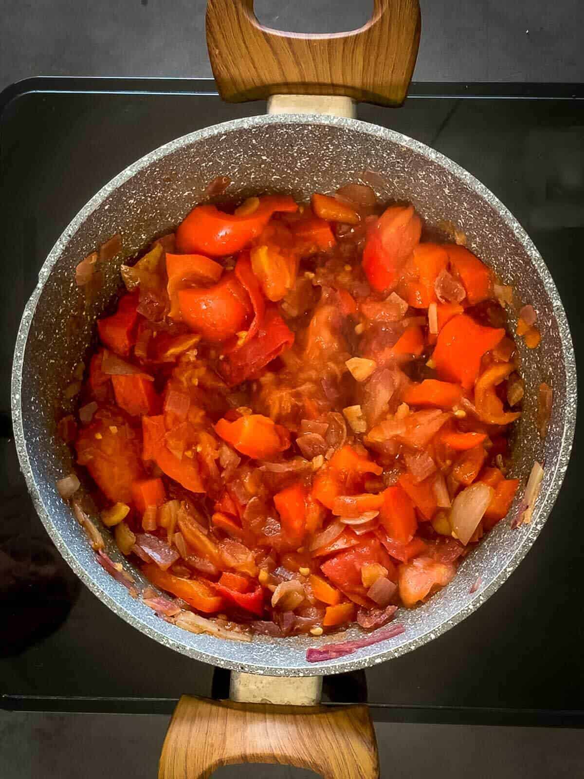 add tomatoes to vegan chili saucepan.