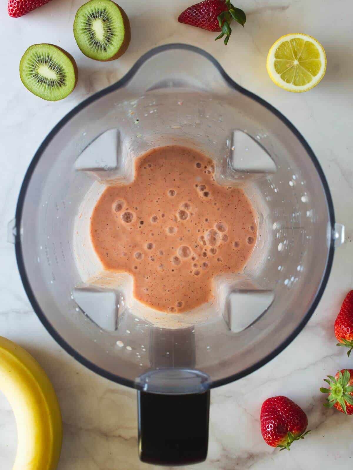 strawberry kiwi banana smoothie liquid in blender