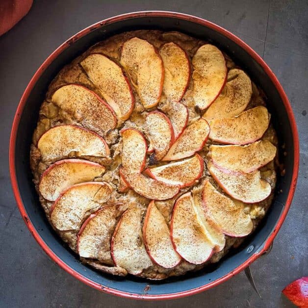 baked apple slices arranged in a spiral pattern on top of the batter