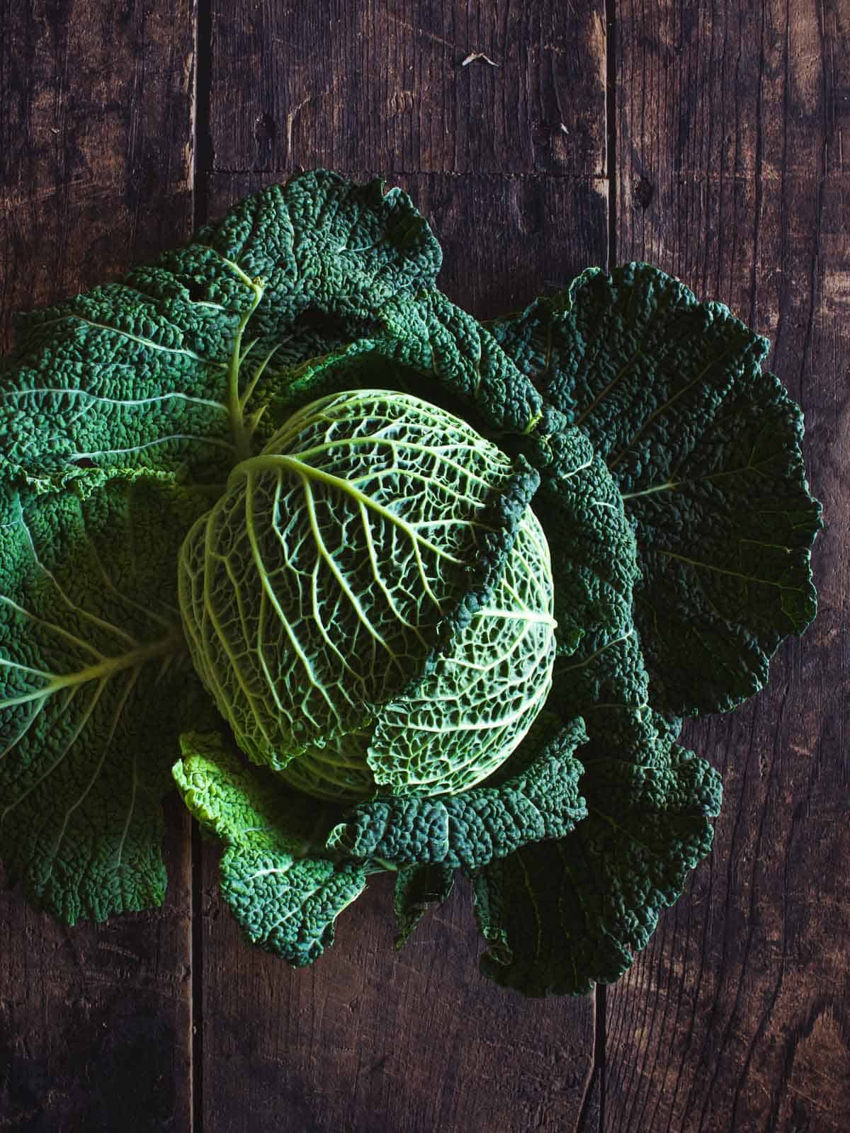 savoy cabbage over wooden table