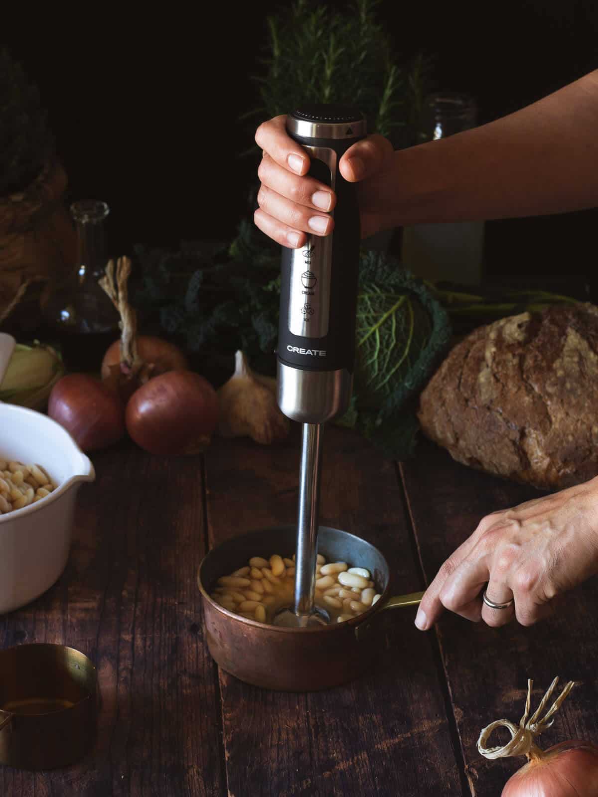 blending half of the white beans with immersion blender