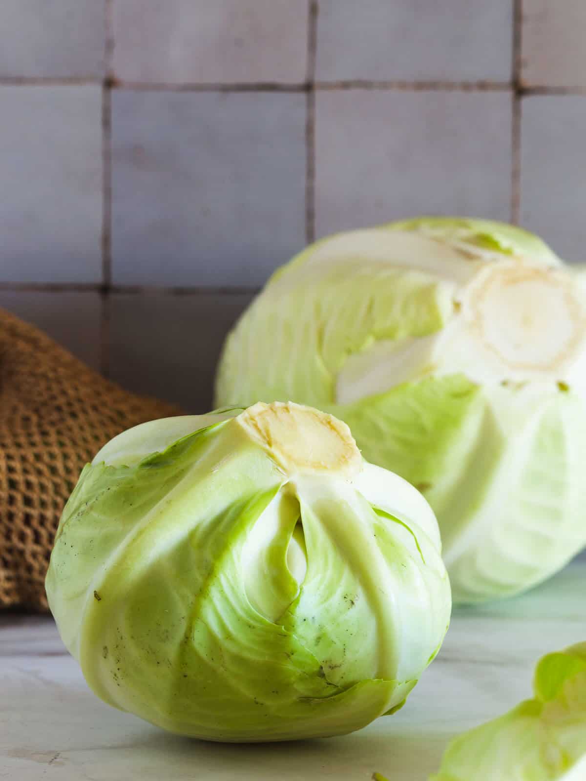 two whole green cabbage heads