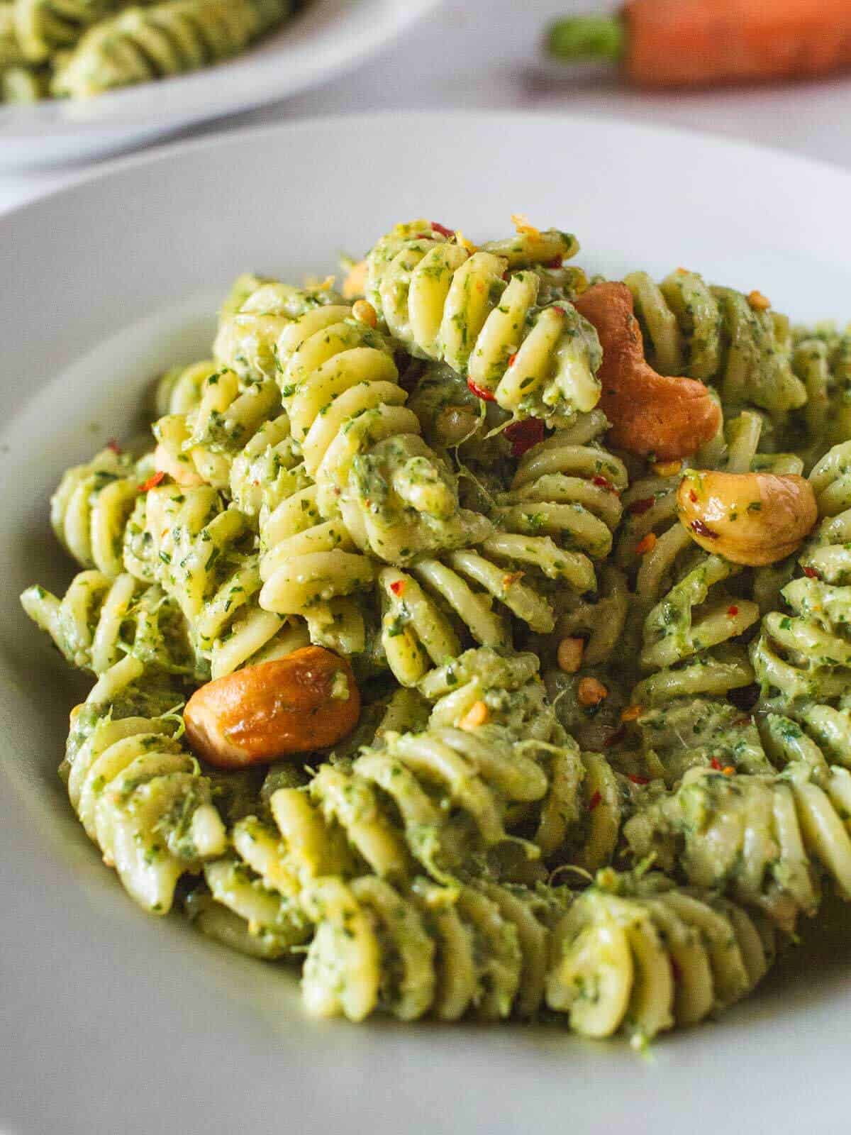 served carrot greens pesto pasta salad topped with cashews