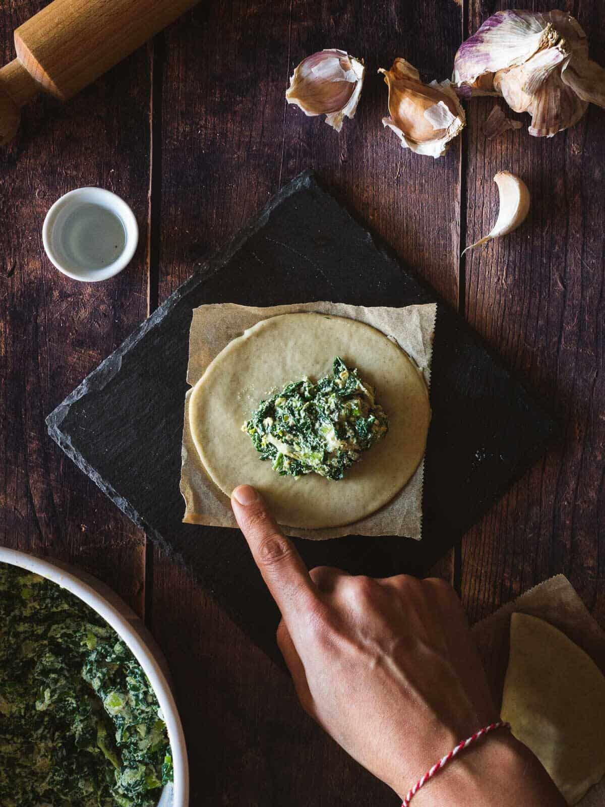 spinach filling on top of empanada circle