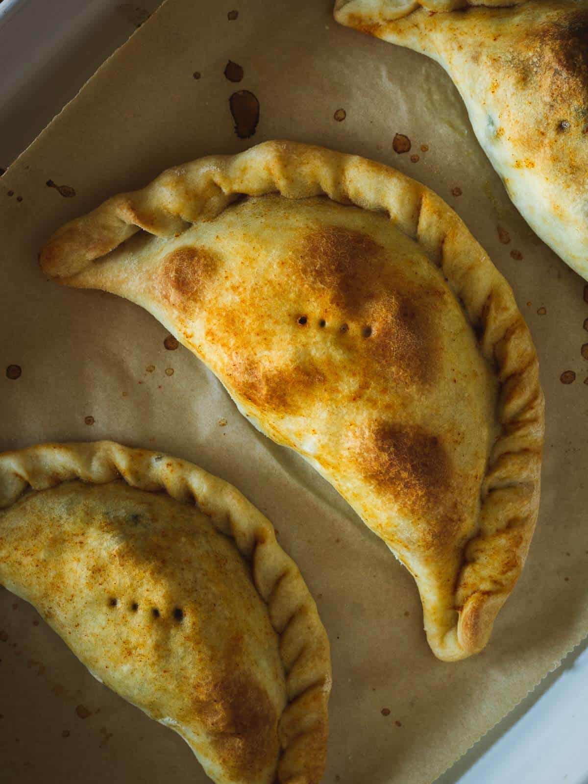 spinach empanadas out of the oven pinched with a fork