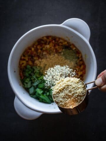 adding vegan parmesan cheese to the portobello stuffing